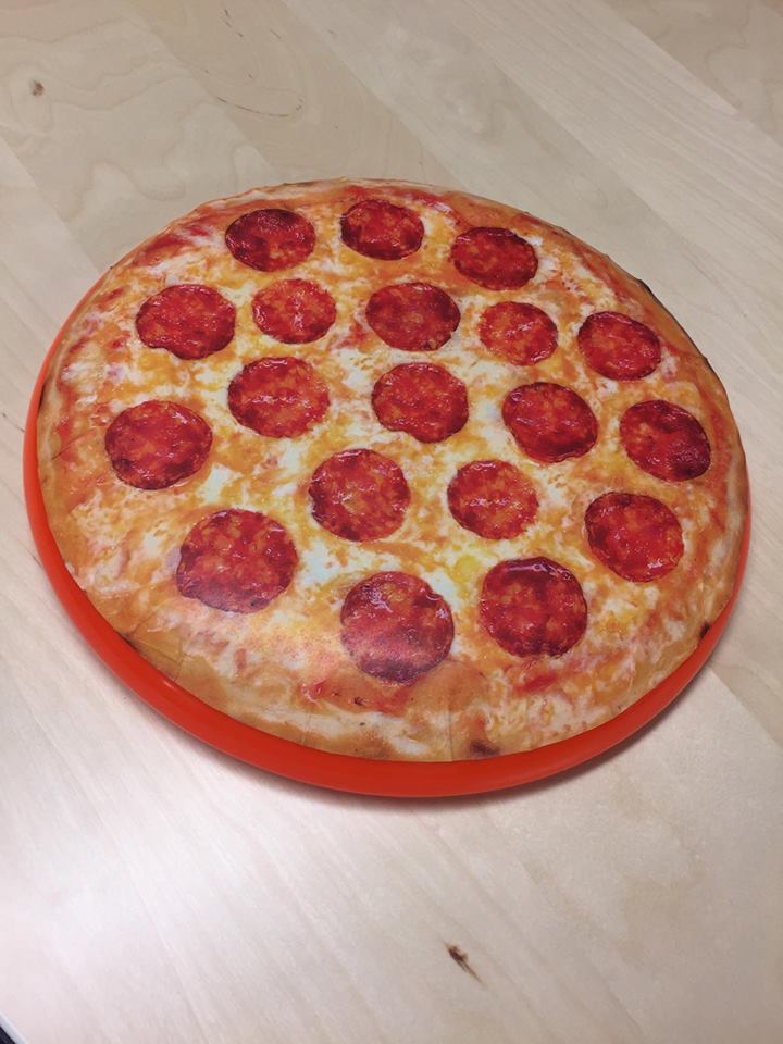A pepperoni pizza is sitting on a wooden table.
